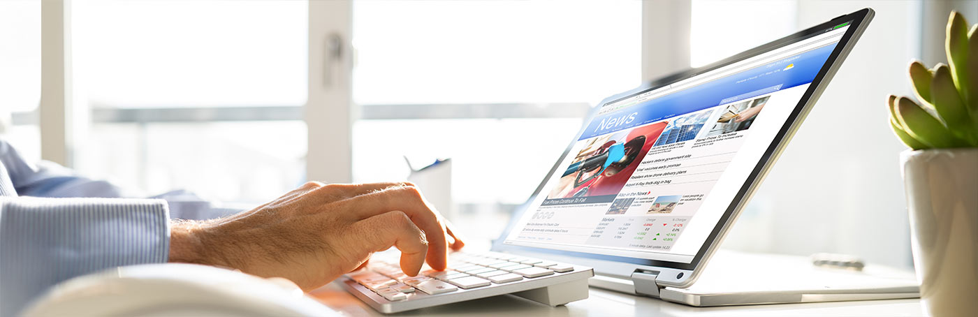 person scrolling a news feed on a computer
